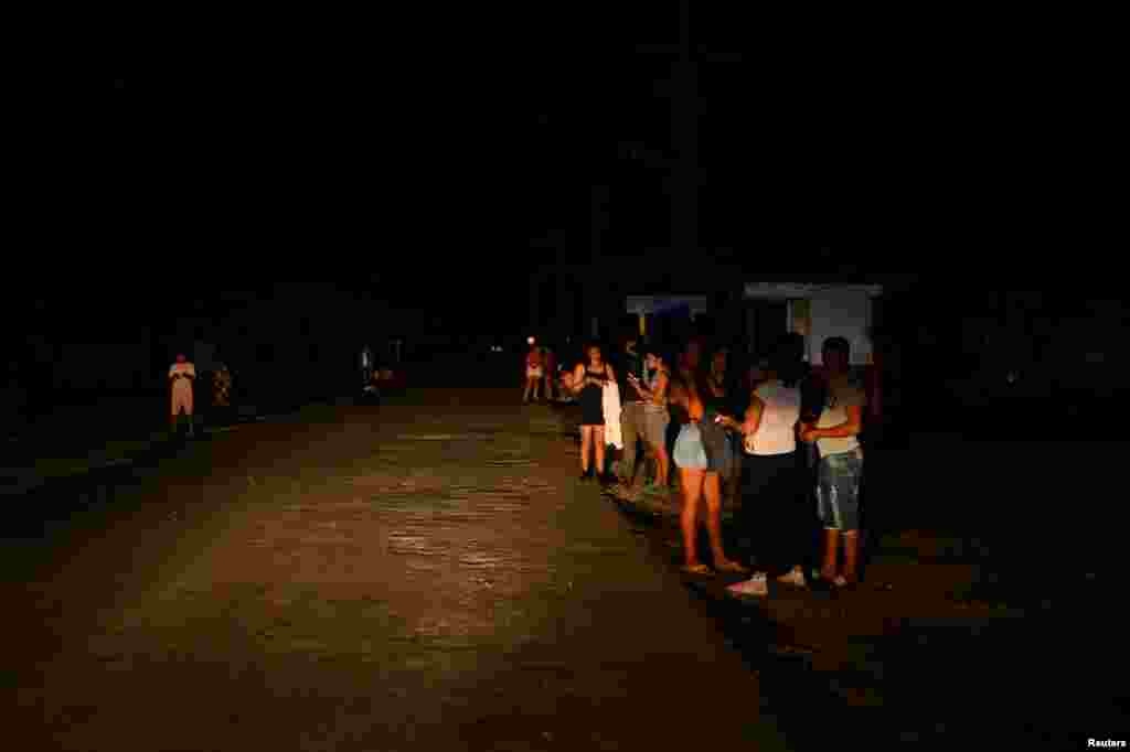 La gente se congrega en la calle en busca de servicio telefónico y de internet durante un apagón, en Palpite, Ciénaga de Zapata, Cuba, 7 de abril de 2026. REUTERS/Norlys Perez
