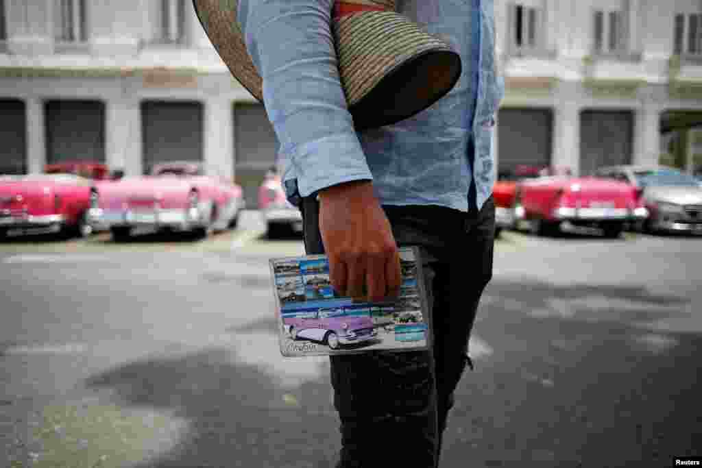 Un taxista sostiene un paquete con ofertas de recorridos para turistas en La Habana. REUTERS/Fernando Medina