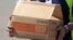 Un hombre lleva una caja con paquetes con ayuda humanitaria traída por Estados Unidos para Venezuela.