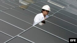 Un empleado de Hong Kong Electric (HKE) comprueba el funcionamiento de los paneles solares recién instalados en el tejado de la estación eleéctrica Lamma de HKE, en Hong Kong (China). 