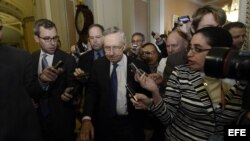 El líder de la mayoría demócrata del Senado estadounidense, Harry Reid (c), avanza rodeado por numerosos periodistas tras su reunión con el líder de la minoría, Mitch McConnell (no aparece), en el Capitolio, Washington (Estados Unidos), hoy, lunes 14 de o