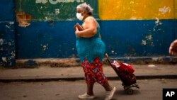 Una mujer usa una máscara protectora contra el coronavirus en una calle de La Habana.