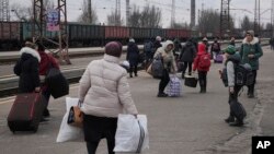 Personas que le escapan a la guerra tras la invasión rusa esperan un tren en la estación de Kostiantynivka, en Donetsk, el este de Ucrania, el 24 de febrero del 2022. (AP Photo/Vadim Ghirda)