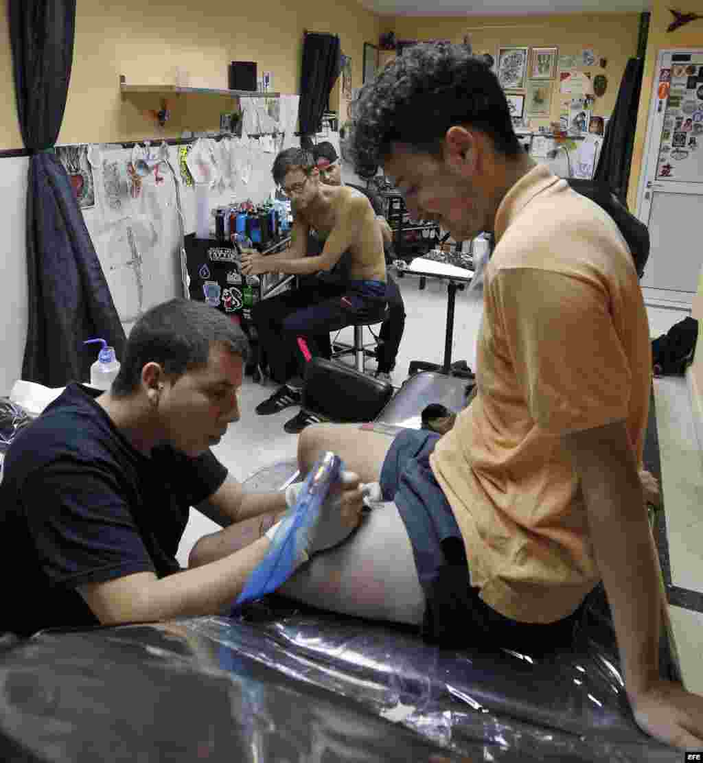 Jóvenes se tatúan en La Marca, el primer estudio de tatuajes "profesional" cubano. EFE