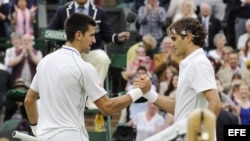 El tenista suizo Roger Federer (d) saluda al serbio Novak Djokovic (i) tras derrotarle en su partido de semifinales del Torneo de Wimbledon jugado el viernes 6 de julio de 2012.
