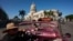 Un clásico auto estadounidense convertido en taxi de turismo pasa frente al Capitolio de La Habana. Foto: AP/ Ramón Espinosa