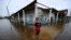 A man carries a dog as he wades through a flooded street after the passage of Hurricane Rafael in Batabano. 