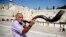 Un judio ultraortodoxo hace sonar un "Shofar" con el que se pide a Dios que se perdonen todos los pecados, delante del muro de las lamentaciones antes del comienzo de la festividad del Yom Kippur, ó "Día del Perdón". 