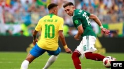 El delantero brasileño Neymar y el centrocampista mexicano Hector Herrera (d) durante el partido Brasil-México.