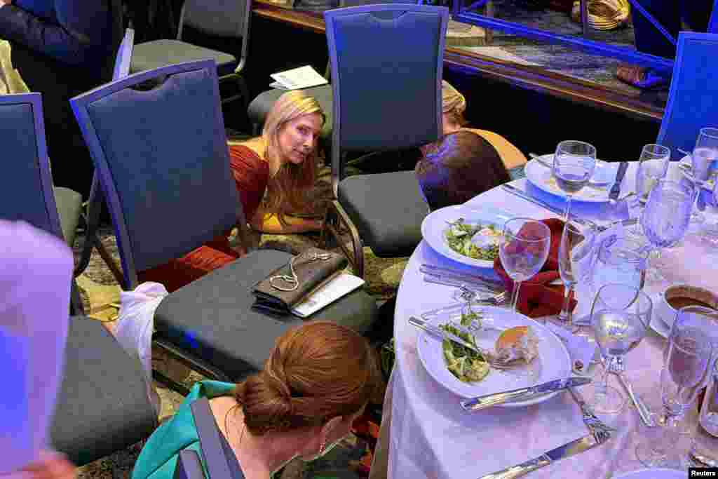 Los invitados se ponen a cubierto después de que el presidente Donald Trump y la primera dama, Melania Trump, fueran evacuados de la cena de la Asociación de Corresponsales de la Casa Blanca por agentes del Servicio Secreto tras disparos.