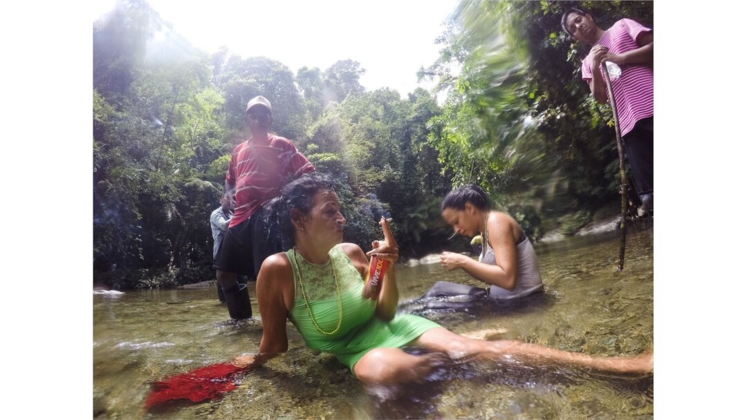 Un descanso breve después de cruzar un río en el Tapón de Darién, la jungla salvaje que envuelve la frontera entre Colombia y Panamá. (Fotografía de Lisette Poole. Screenshot NPR)
