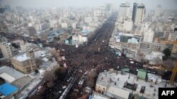 Iraníes marchan tras un vehículo que carga el ataúd de Qassem Soleimani.