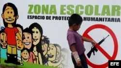 Una señal que prohibe el uso de armas en una pared de una escuela en el casco urbano de Toribio, Cauca, en Colombia.