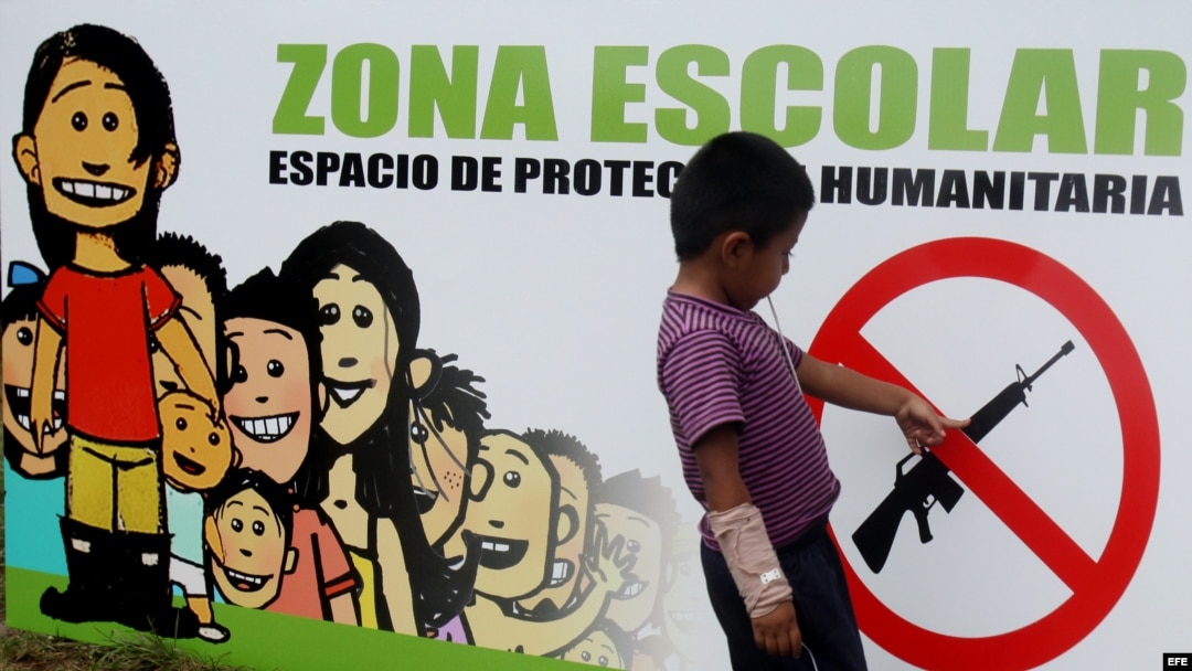 Una señal que prohibe el uso de armas en una pared de una escuela en el casco urbano de Toribio, Cauca, en Colombia.