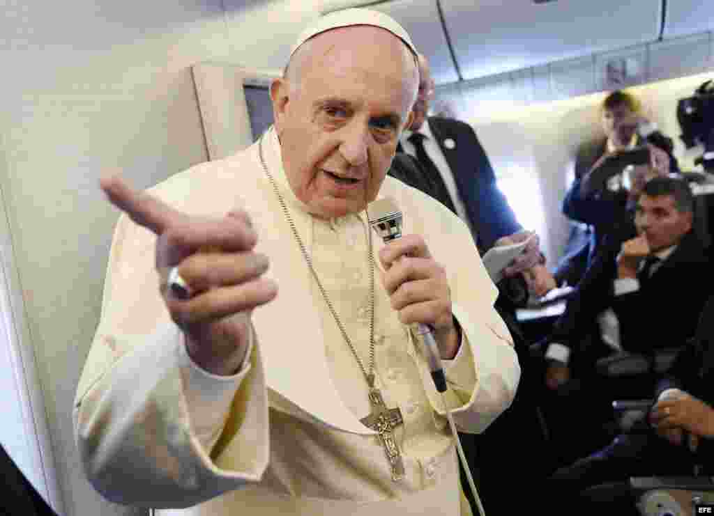 El papa Francisco (c) se dirige a los periodistas durante el vuelo del Boeing 777 de la compañía Korean Airlines que le traslada desde Corea del Sur hasta Italia.