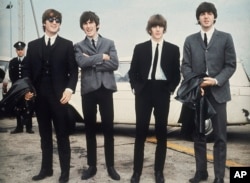 Los Beatles, de izquierda a derecha, John Lennon, George Harrison, Ringo Starr y Paul McCartney llegan a Liverpool, Inglaterra, el 10 de julio de 1964, para el estreno de su película "A Hard Day's Night". (AP Photo, File)