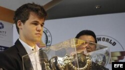 El Campeón del Mundo de Ajedrez, el noruego Magnus Carlsen, de 22 años, sostiene su trofeo durante la ceremonia de premiación del Campeonato Mundial de la FIDE celebrada en Chennai (India), hoy, lunes 25 de noviembre de 2013.