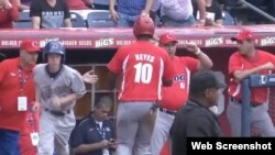 Un pelotero cubano es felicitado al regresar al dugout .