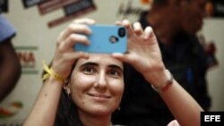 La cubana Yoani Sánchez, autora del blog "Generación Y", toma una foto durante su primera jornada de visita a Brasil hoy, lunes 18 de febrero de 2013, en Feira de Santana.