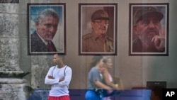 ARCHIVO - Las imágenes enmarcadas (de izquierda a derecha) del presidente de Cuba, Miguel Díaz-Canel, Raúl Castro y Fidel Castro, adornan una pared en un edificio estatal en La Habana, Cuba, el 20 de mayo de 2026. (AP Foto/Ramón Espinosa, archivo)