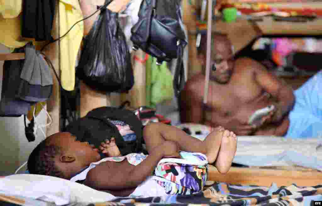 Fotografía del 31 de julio de 2016 de ciudadanos cubanos en tránsito en la población de Turbo (Colombia). Hacinados en improvisados albergues en la localidad colombiana de Turbo unos 2.000 cubanos, hombres mujeres y niños, pasan los días esperando noticia