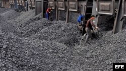 Trabajadores amontonan carbón en una estación de procesamiento de Beishan, cercano a Shanyang, China, que es mayor consumidor de carbón.