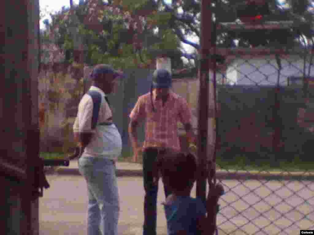 Agente de la polic&iacute;a amenaza con detener al disidente Ren&eacute; Rouco (con pull&oacute;ver blanco) si sale de su casa en La Habana durante visita de Benedicto XVI.
