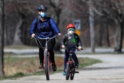 Estos ciclistas en Portland (Maine), en abril 2020, ejemplifican el surgimiento de actividades familiares y al aire libre, durante la pandemia de coronavirus. Foto: © Robert F. Bukaty/AP Images/Archivo.