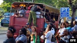  Varias personas suben a un camión de transporte de pasajeros en Santiago de Cuba.