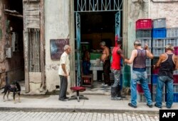 Cubanos hacen cola para comprar huevos en una bodega en La Habana.