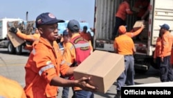 Obreros aeroportuarios embarcan ayuda humanitaria desde Venezuela a Cuba.