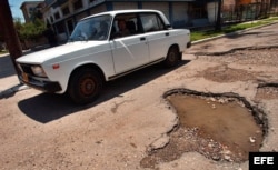 Un automóvil trata de evitar los baches de las calles de La Habana, Cuba.