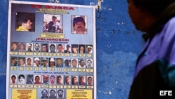  Una persona observa uno de los carteles en el municipio de Monterrey,925 kilómetros de la capital mexicana que ofrecen recompensas de hasta 5 millones de dólares por información que lleve a la captura de el narcotraficante Joaquín Guzmán Loera, alias "El