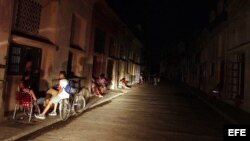 ARCHIVO. Varias personas conversan iluminadas por la luz de un automóvil en una calle del populoso barrio El Cerro.