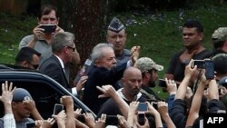El ex presidente de Brasil (2003-2011) Luiz Inácio Lula da Silva (C-saludando) es acompañado por las fuerzas de seguridad al llegar al cementerio Jardim da Colina, en Sao Bernardo do Campo, Sao Paulo, Brasil.