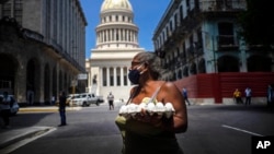 Una mujer carga un cartón de huevos cerca del Capitolio, en La Habana. (AP Photo / Ramon Espinosa).