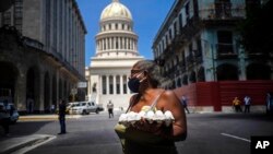 Una mujer carga un cartón de huevos cerca del Capitolio, en La Habana. El cartón de 30 huevos ha pasado en La Habana de los 600 pesos cubanos (CUP) (25 dólares/23 euros al cambio de hoy) a los 2.000 CUP (83,35 dólares/77,12 euros) (AP Photo/Ramon Espinosa)