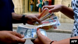 Una mujer cambia dólares en una calle de La Habana (YAMIL LAGE / AFP)