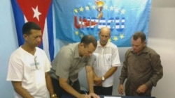 José Daniel Ferrer (centro) firma un documento junto a Ovidio Martín (primero izq.)