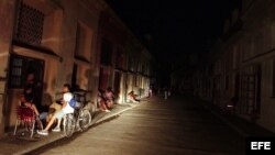 En medio de un apagón, varias personas esperan afuera de sus viviendas, en la barriada del Cerro, en La Habana, a que "llegue la luz". (Archivo)