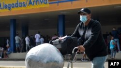 Un cubano residente en Estados Unidos arriba cargado de paquetes al Aeropuerto Internacional José Martí de La Habana. ( Yamil LAGE / AFP)