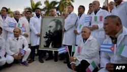 Médicos cubanos de la brigada internacional Henry Reeve posan con un retrato de Fidel Castro antes de partir a Italia, en marzo pasado. (Yamil LAGE / AFP)