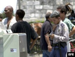 Un policía cubano identifica a dos ciudadanos afroamericanos en la zona de La Habana Vieja.