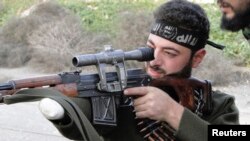 Un rebelde sirio mutilado apunta su arma. Archivo.