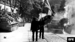 Ciudadanos checoslovacos ondean banderas y queman un carro de combate ante la presencia de los soldados rusos en Praga.