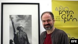 Escritor y periodista mexicano Juan Villoro posa junto a una foto del fallecido fotógrafo cubano Raúl Corrales durante entrevista con Efe.