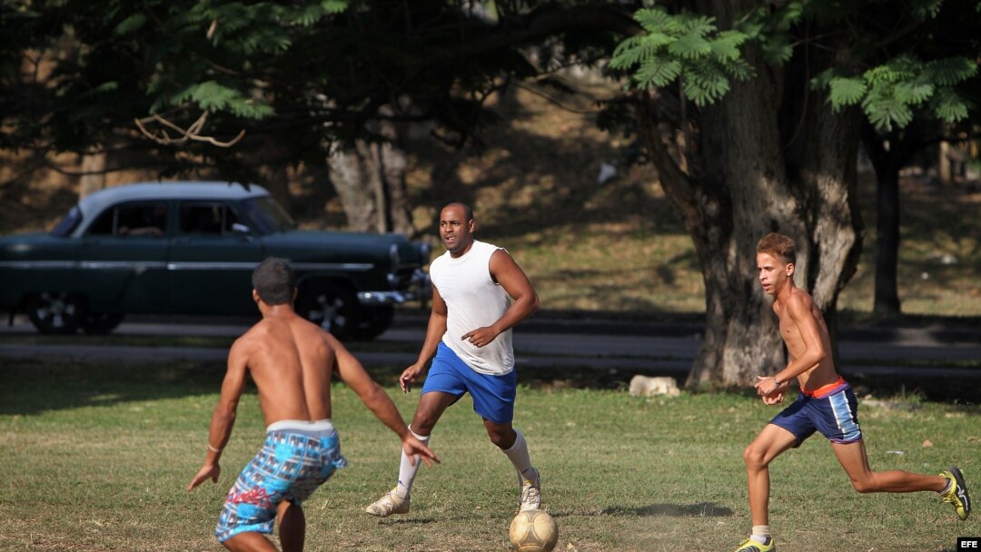 óvenes juegan fútbol en un parque de La Habana