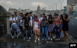 Un grupo de jóvenes camina por el Malecón de La Habana.