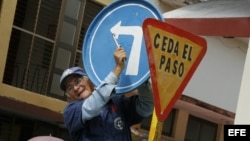 Un hombre instala una señal de tránsito en una calle de la Ciudad de Holguín, Cuba. 