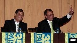 El presidente de Ecuador, Rafael Correa (i), junto a Jorge Glass (d), hijo de Jorge Heriberto Glas Viejó, quien tiene orden de arresto en su contra.